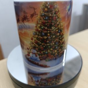 Ceramic mug with colorful Christmas scene featuring Santa, reindeer, snowman, and a decorated Christmas tree