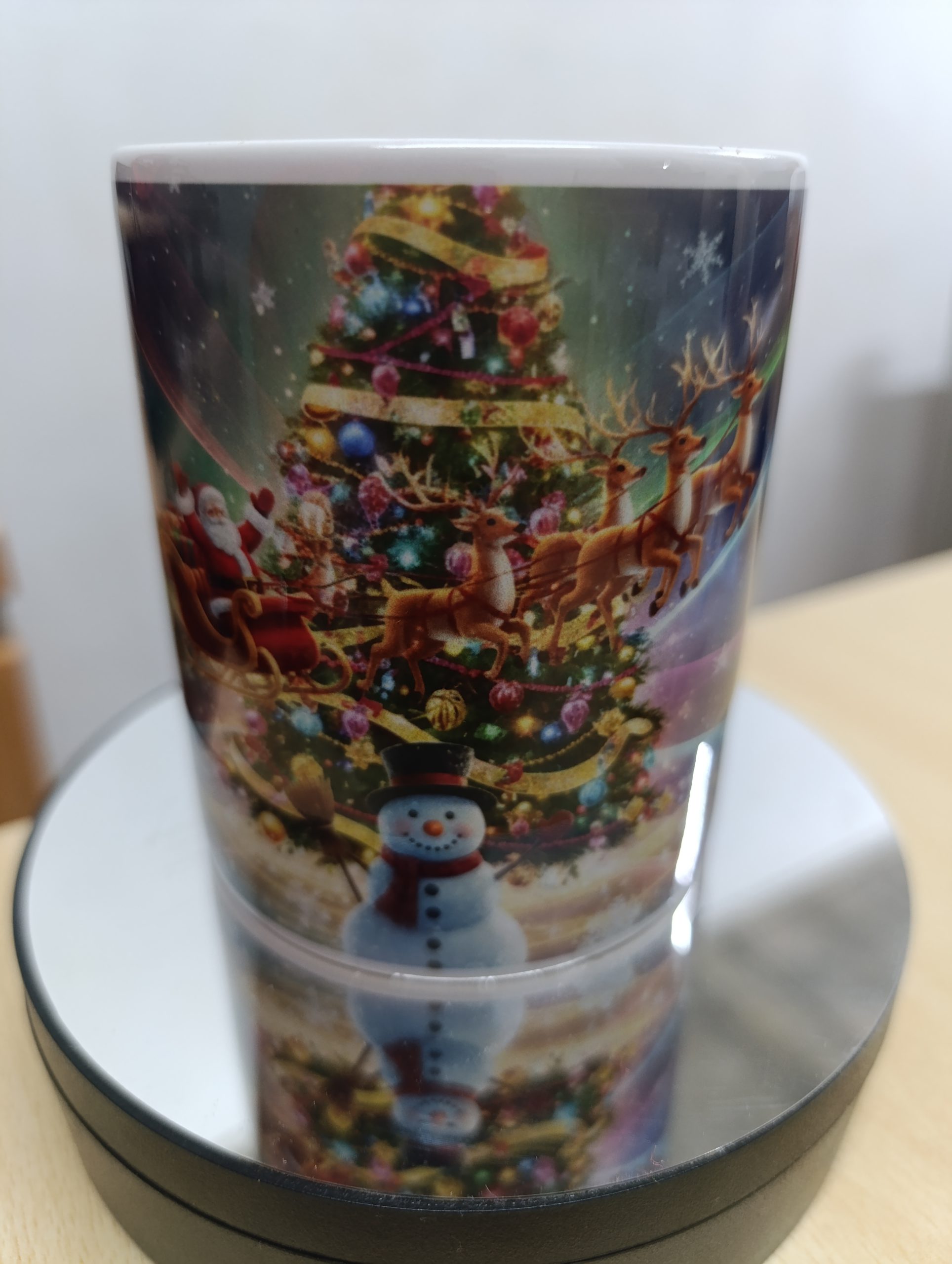 Ceramic mug with colorful Christmas scene featuring Santa, reindeer, snowman, and a decorated Christmas tree